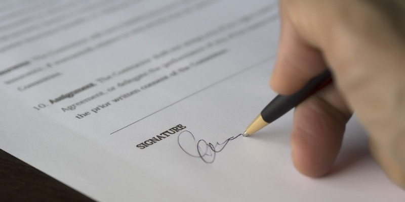 Image of someone signing a document