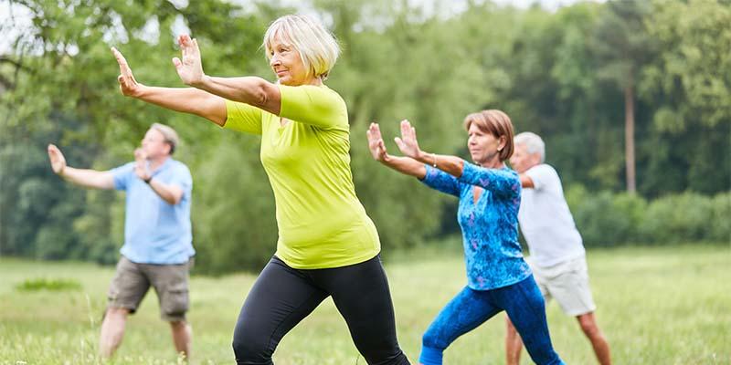 Four adults do Qigong outside