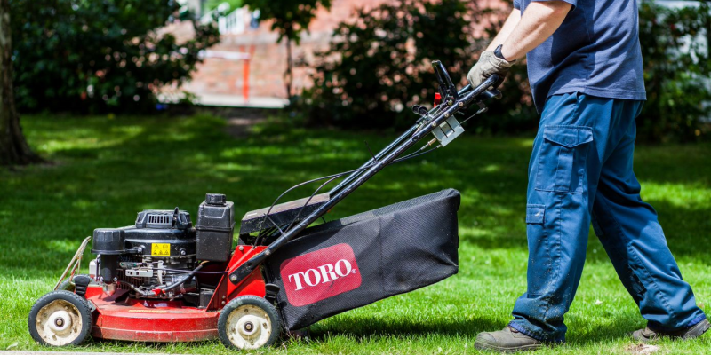 Image of someone mowing grass with a lawnmower