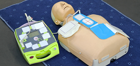 Image of a cpr dummy with a aed attached for training.